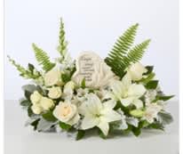 White floral sympathy arrangement with lilies and roses around a memorial plaque
