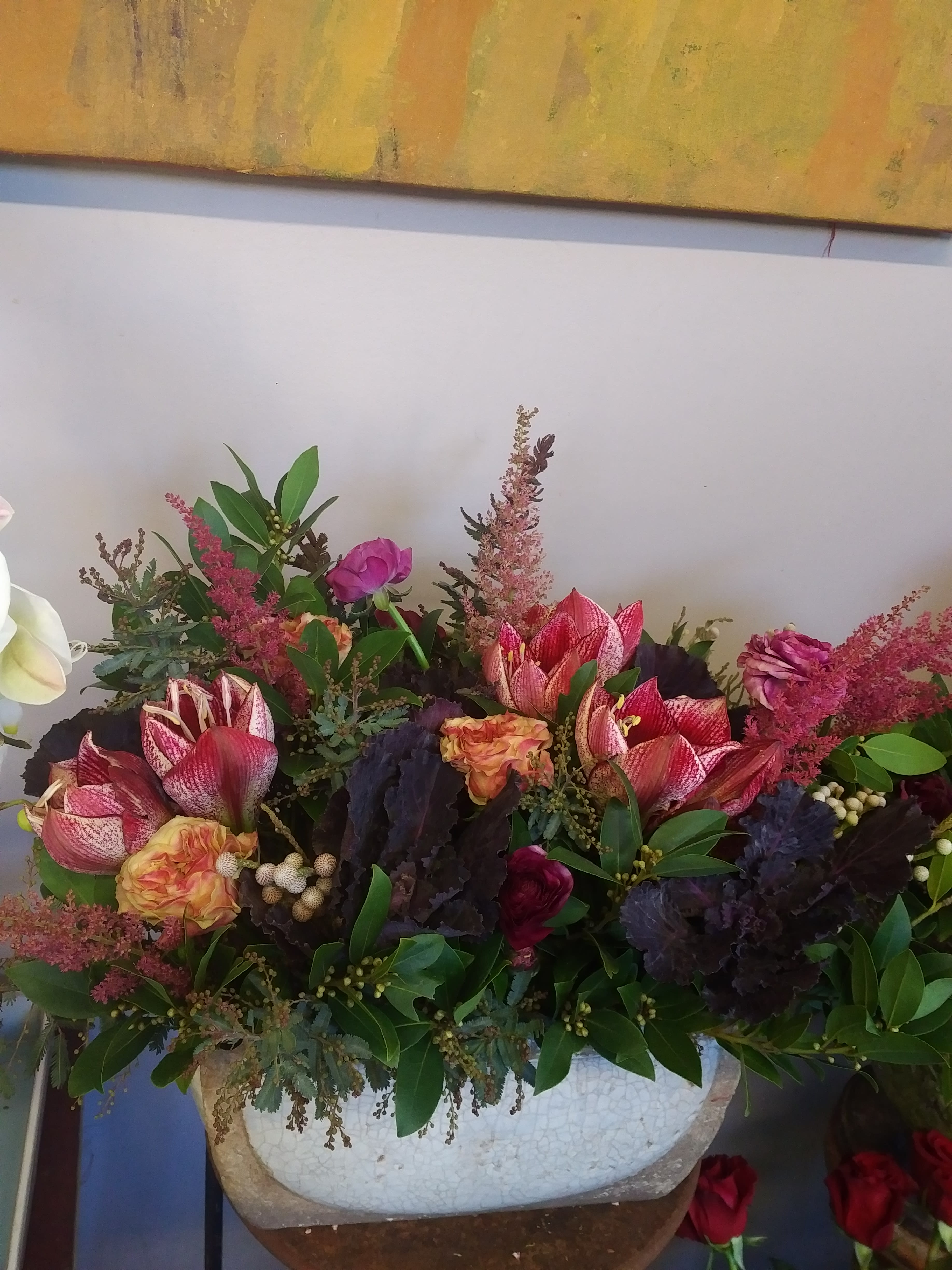 Mixed floral arrangement with pink and red blooms in a white vase