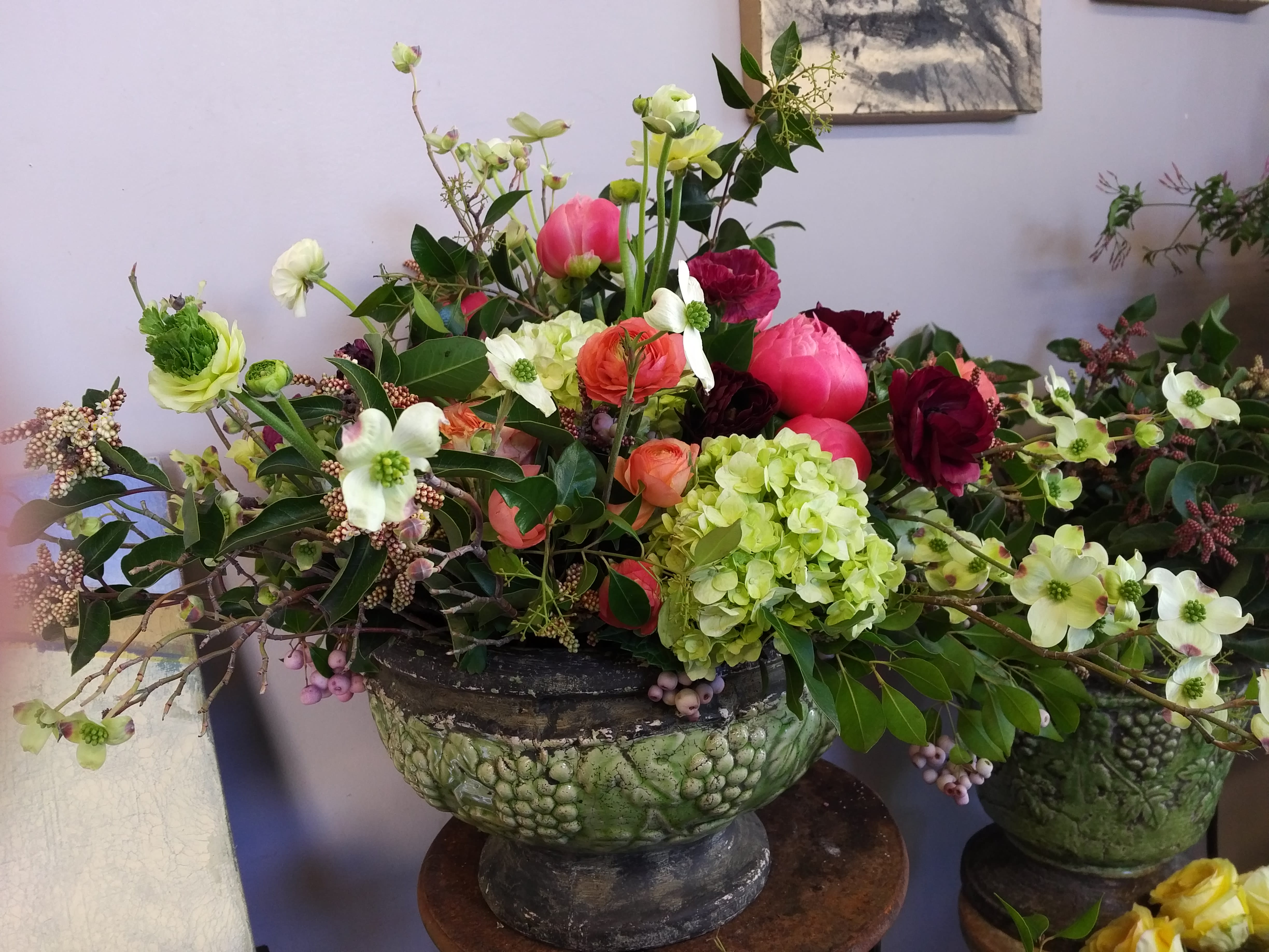 Large mixed floral arrangement in a green pedestal bowl