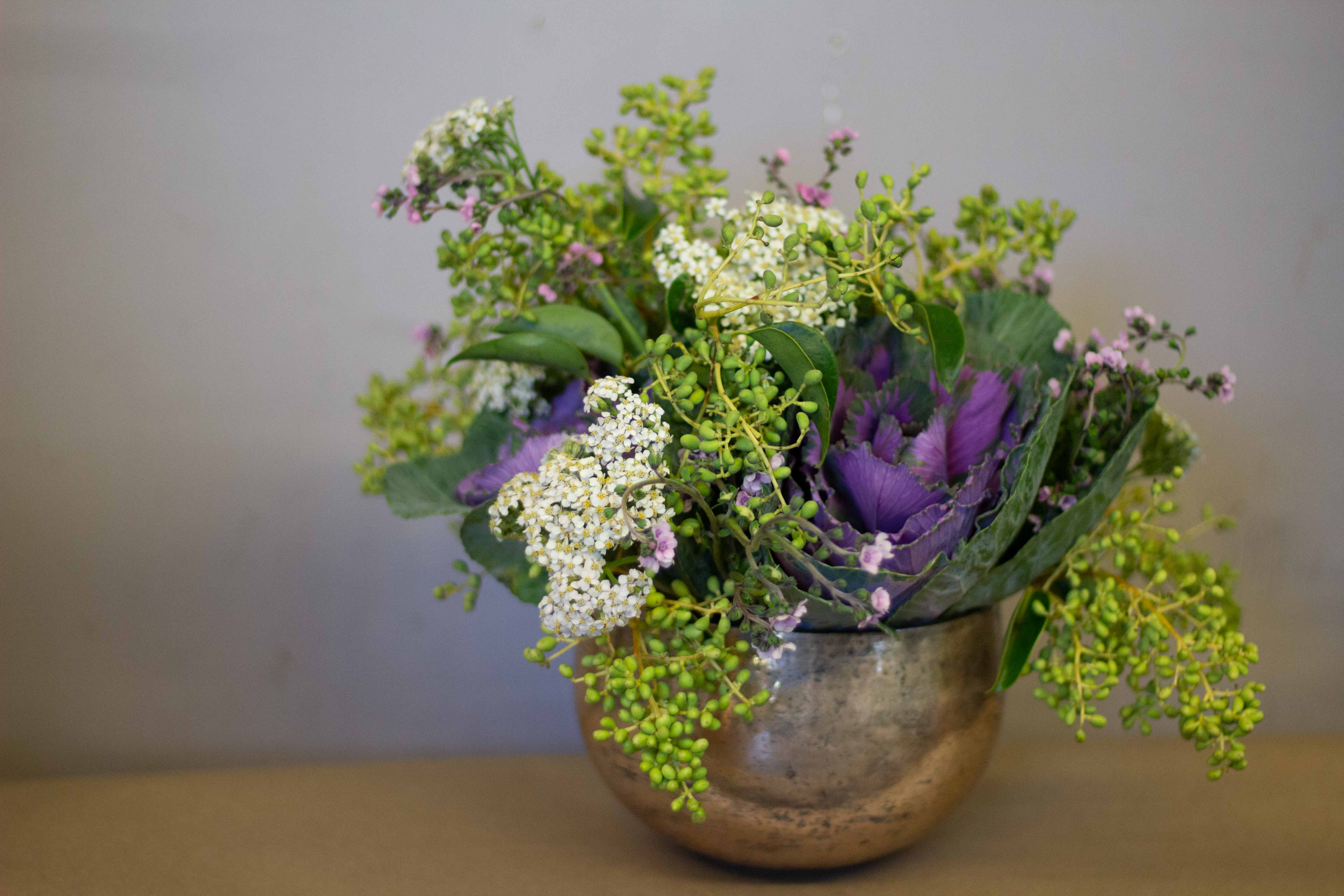 Purple and white floral arrangement in a metallic bowl vase