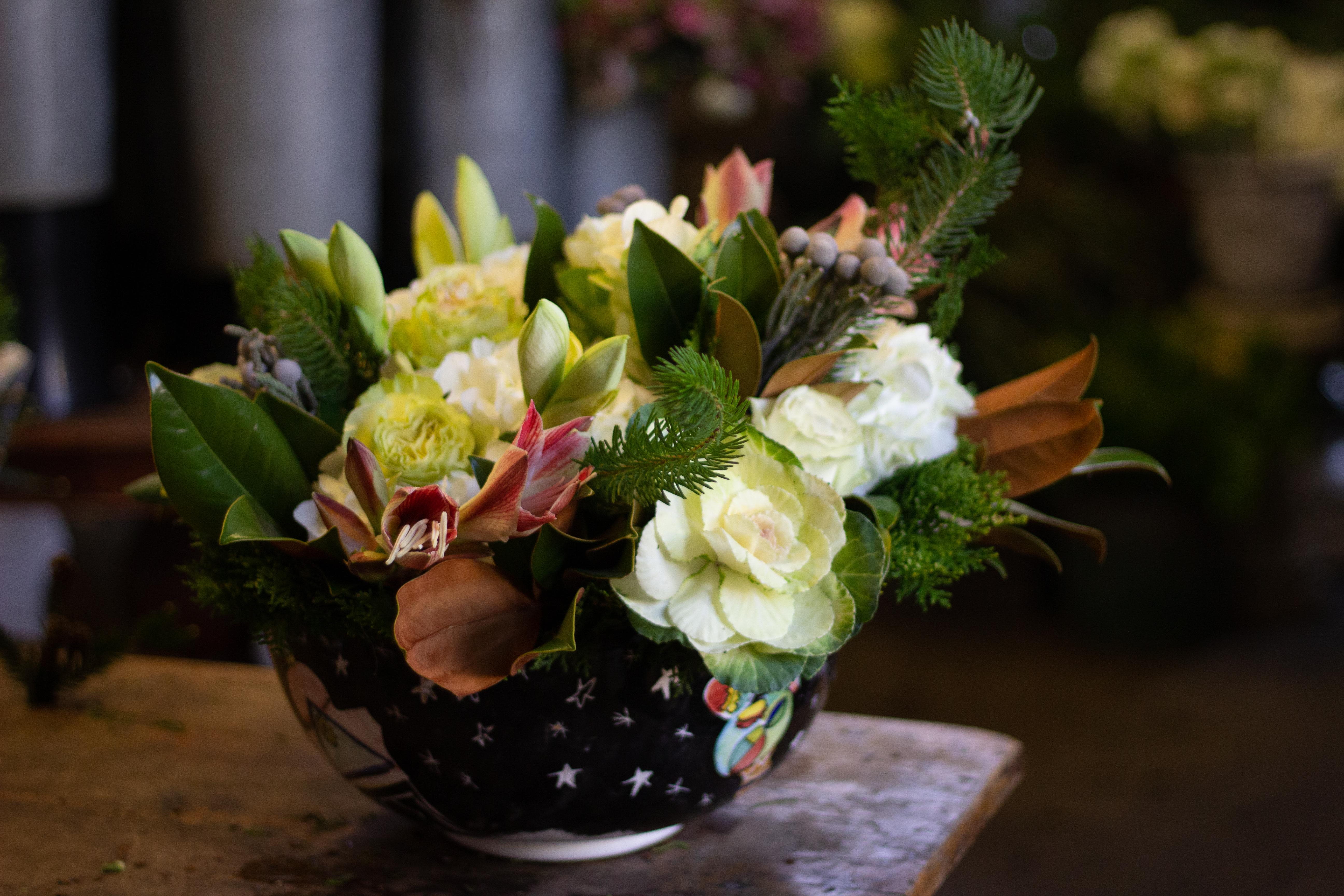 Mixed floral arrangement in a black bowl with white star pattern