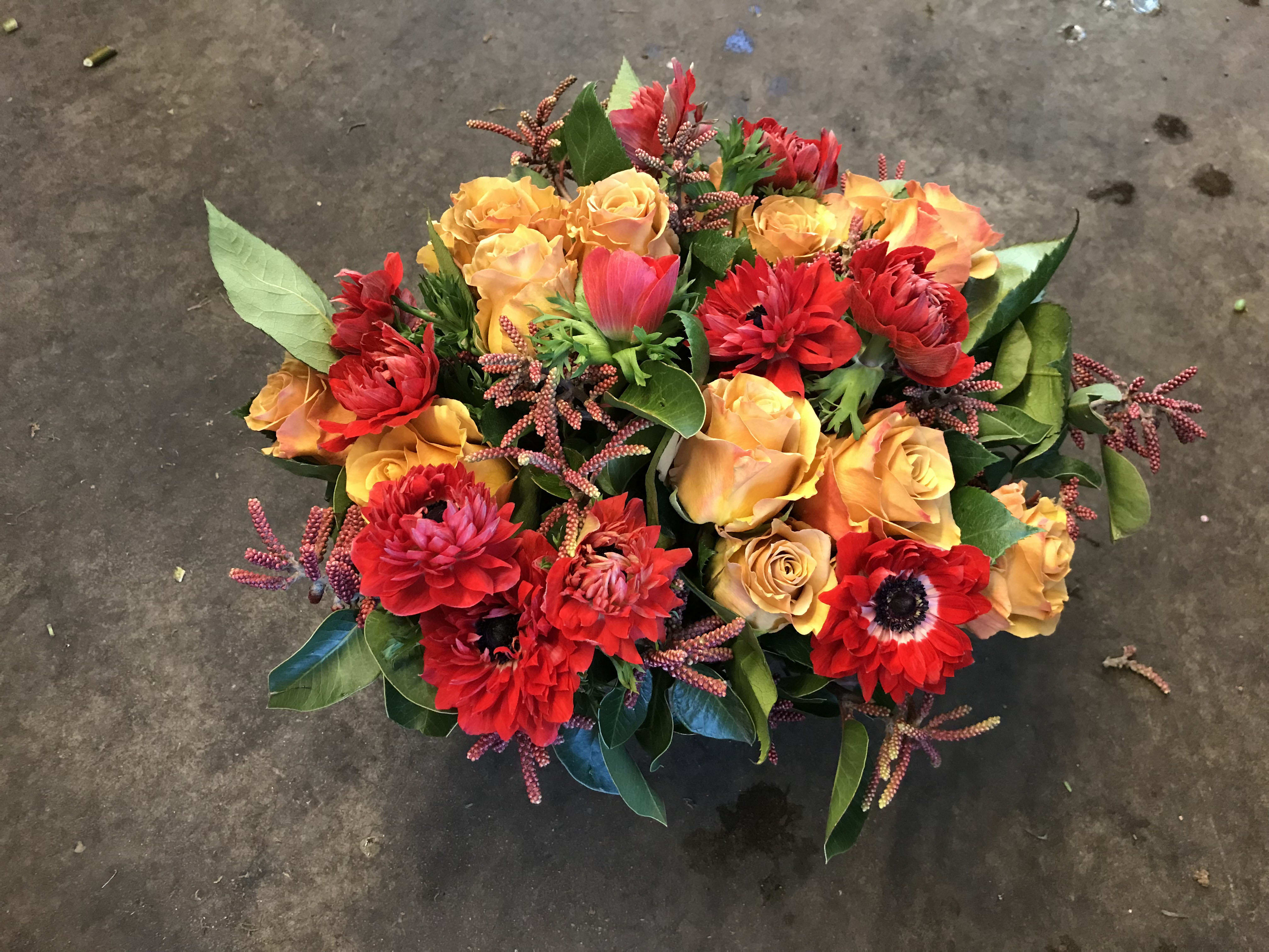 Bouquet of red and orange flowers with green leaves