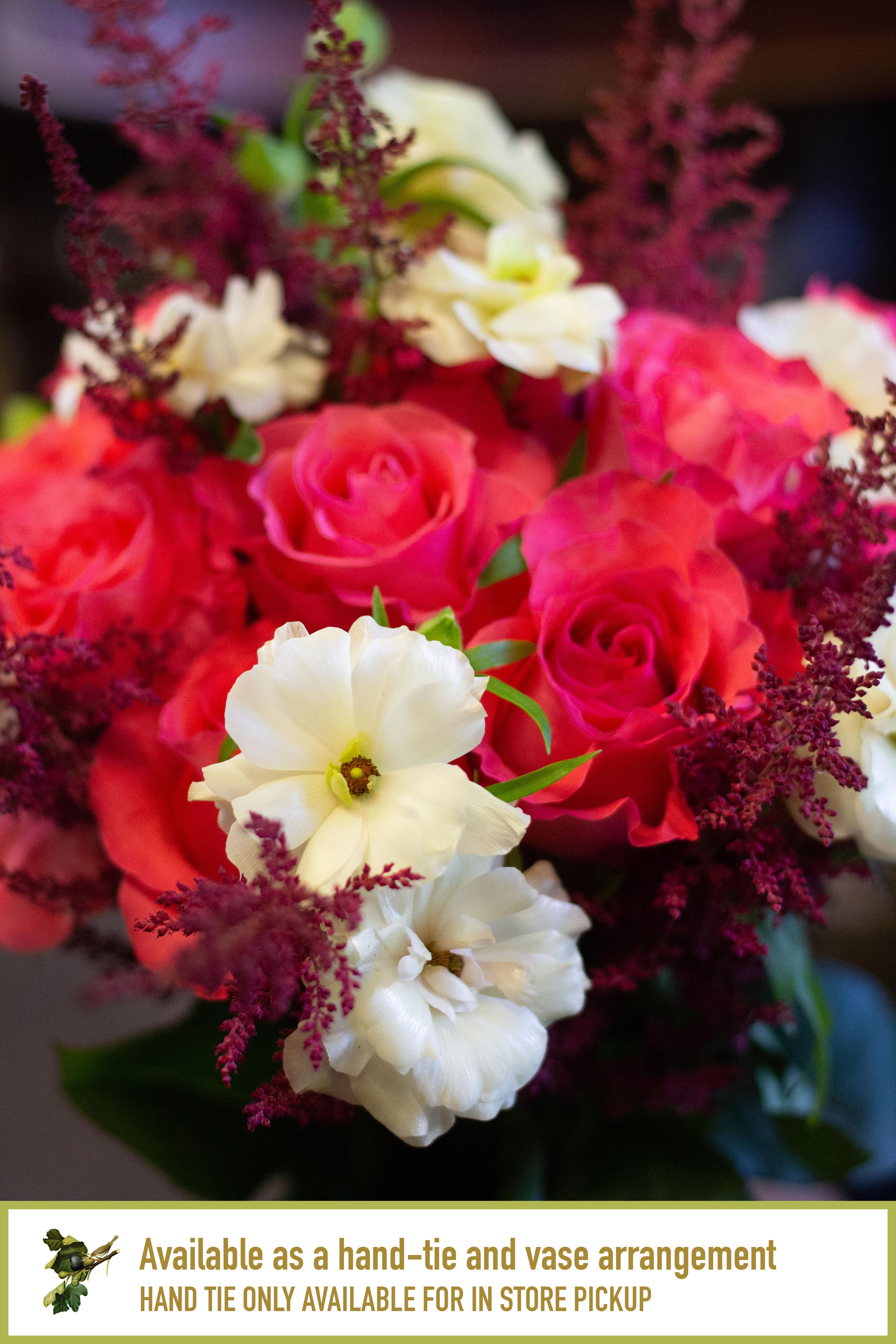 Bouquet of pink roses and white flowers with burgundy filler