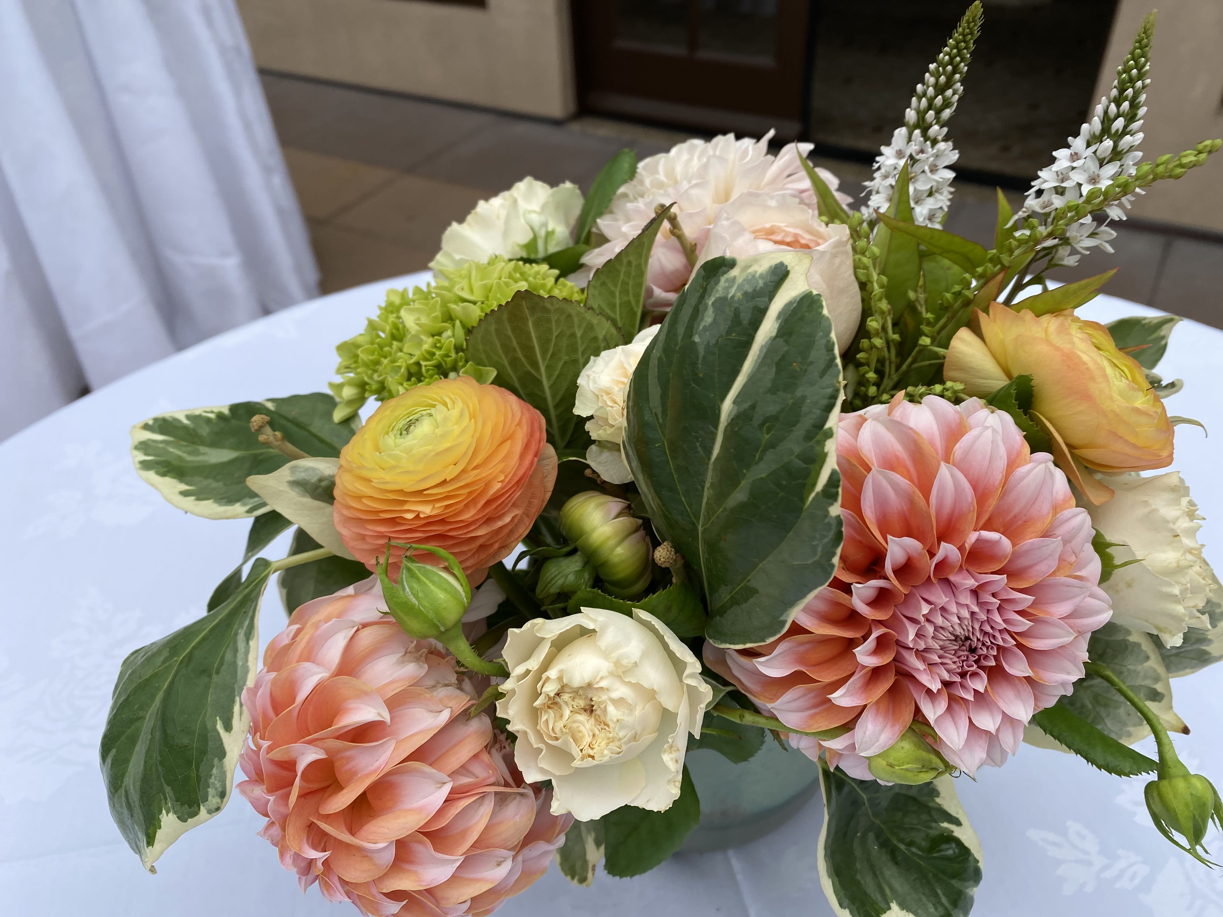 Pastel bouquet with pink dahlias, ranunculus, and white blooms in a vase