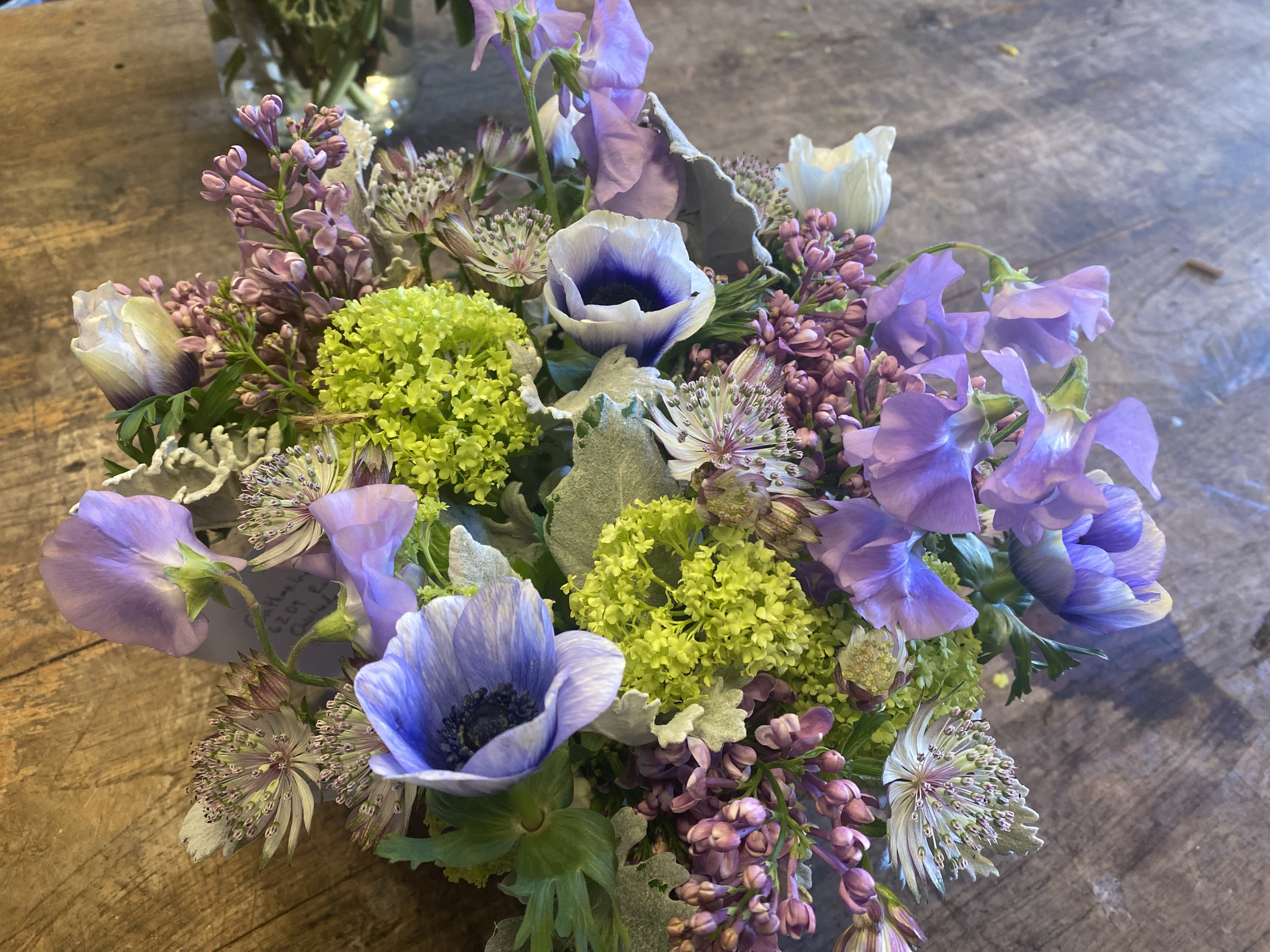 Bouquet of purple and white flowers with bright green accents