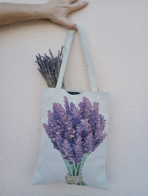 Canvas tote bag with a lavender bouquet print and dried lavender stems peeking out