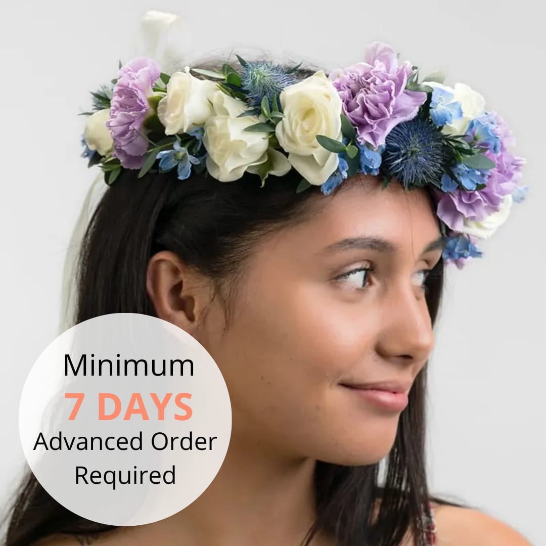 Floral crown of white roses, lavender blooms, and blue accent flowers worn on a woman's head