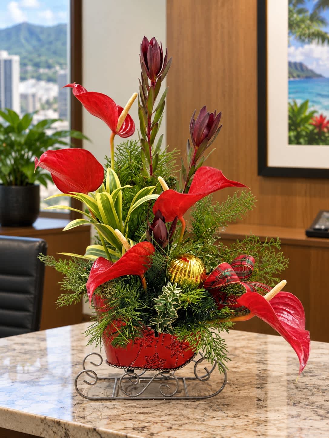 Red anthurium arrangement in a red container with a plaid ribbon