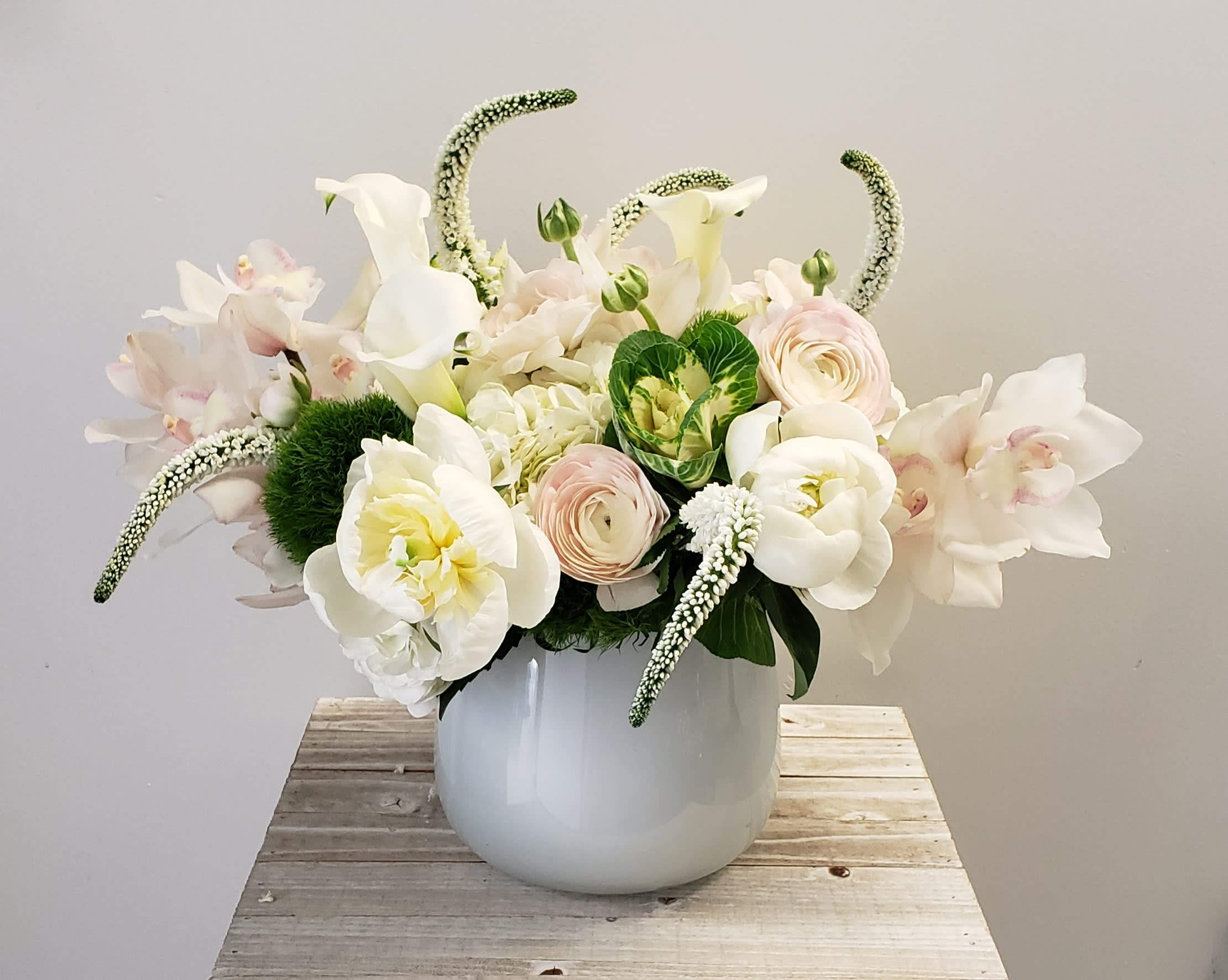White floral arrangement in a round white vase