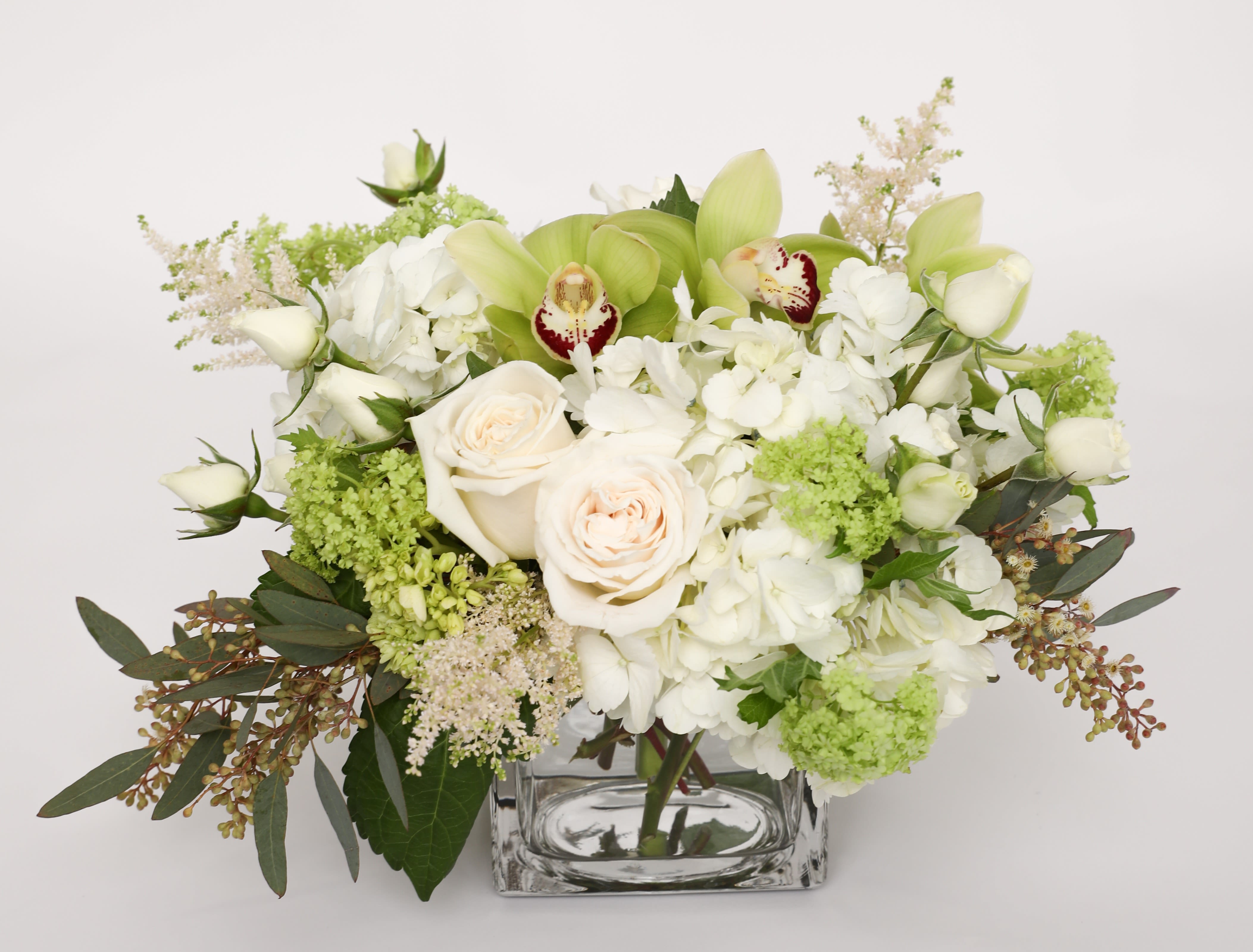 Keep it simple  - This is a 5x5 beautifully designed cube with white &amp; mini green hydrangea, green cymbidium orchids, white spray roses, astilbe, viburnum, roses and seeded eucalyptus.
