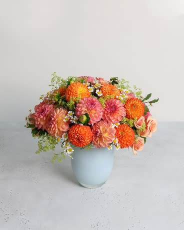 Dahlia Harvest  - Locally grown dahlias, harvested at their peak, bloom in fiery shades of pink and orange. This brilliant gathering pairs the multi-petaled wonders with silky coral spray roses and sweet chamomile blooms.  