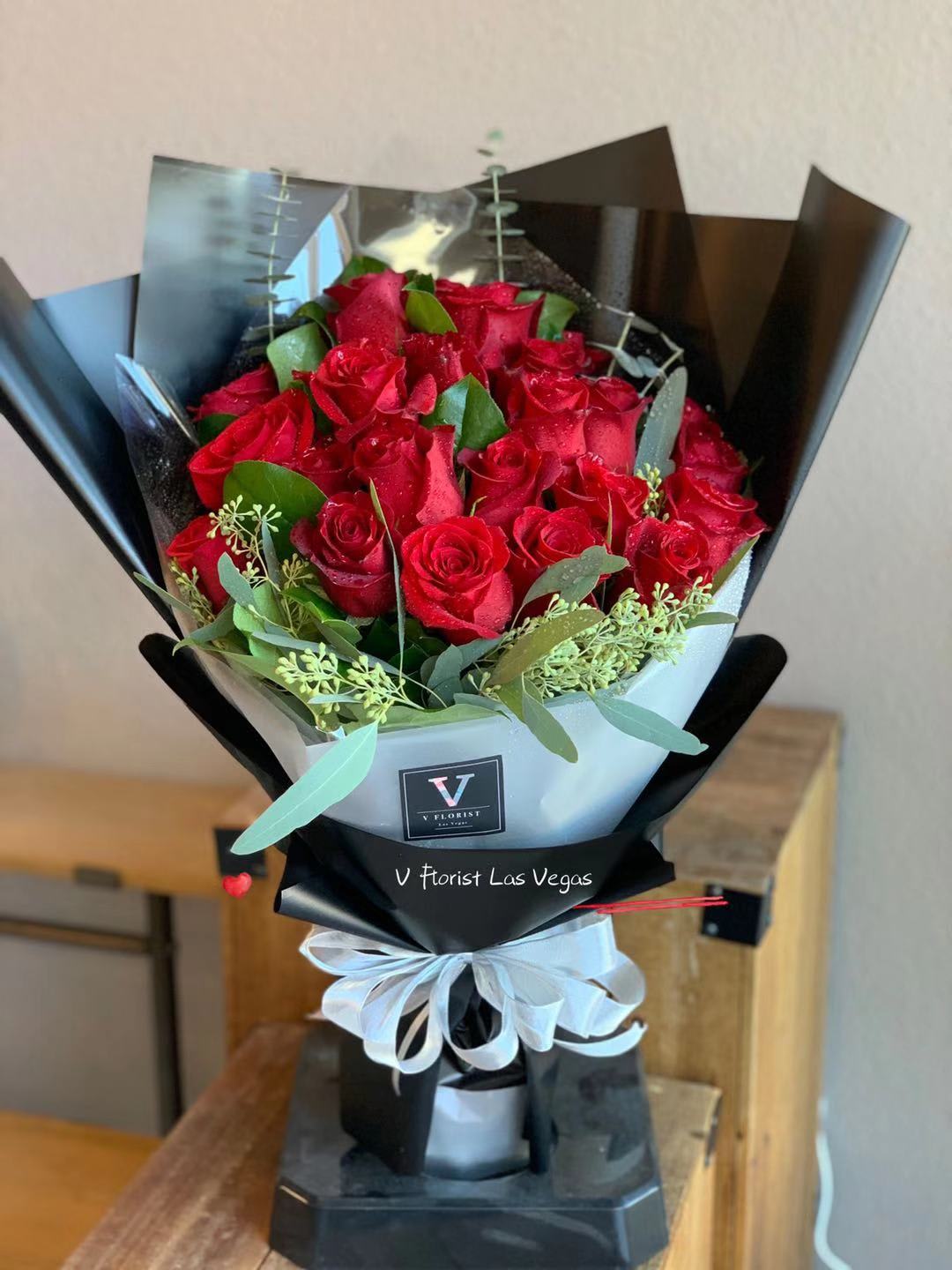 Deluxe Red Rose Wrapped Bouquet (V.2) - 24 Red roses with eucalyptus leaf and seeded eucalyptus in our famous style bouquet. Best for the elegant date night or any special occasion with your loved one.  Our florists select the freshest flowers available, so colors and varieties may vary due to local availability.