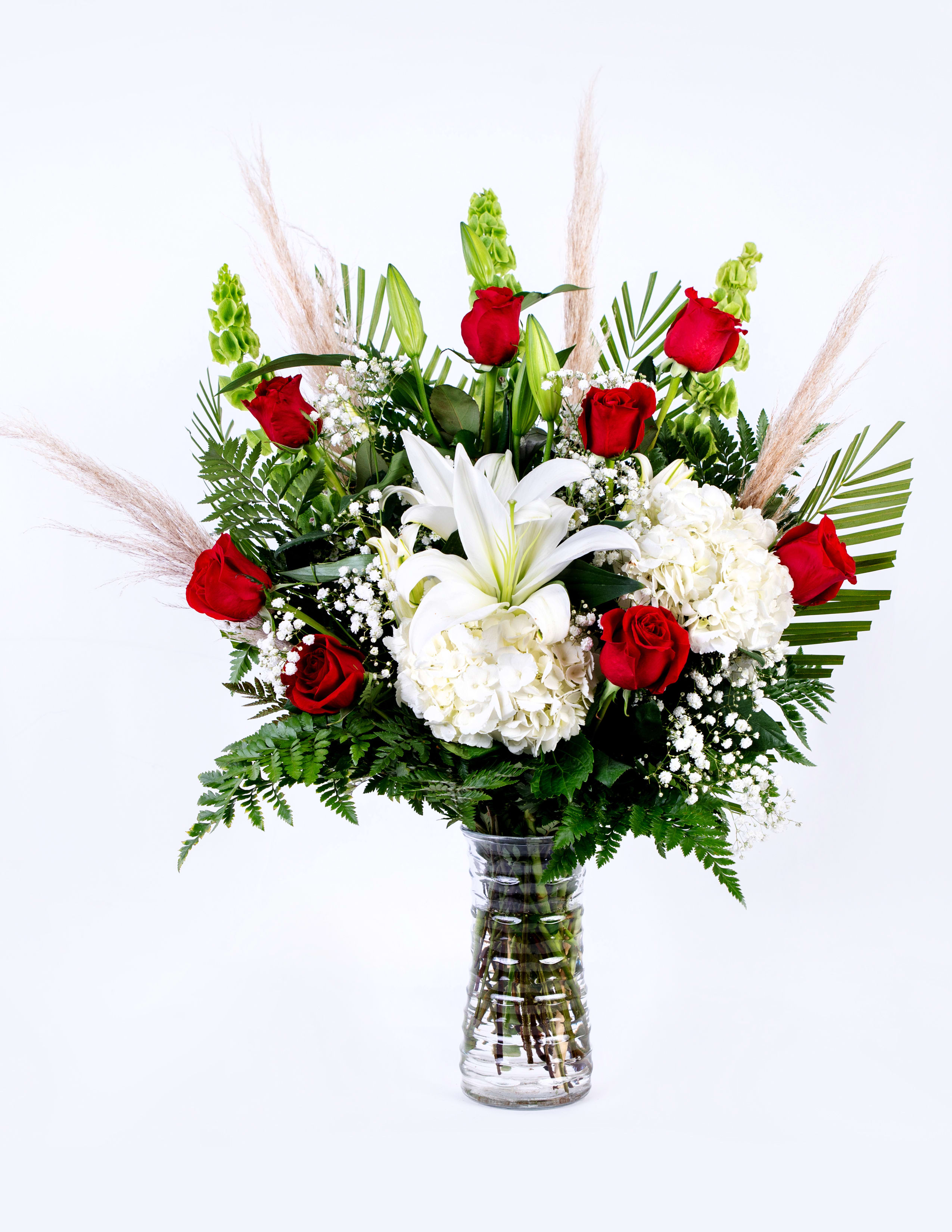 Red roses and white lilies in a clear glass vase