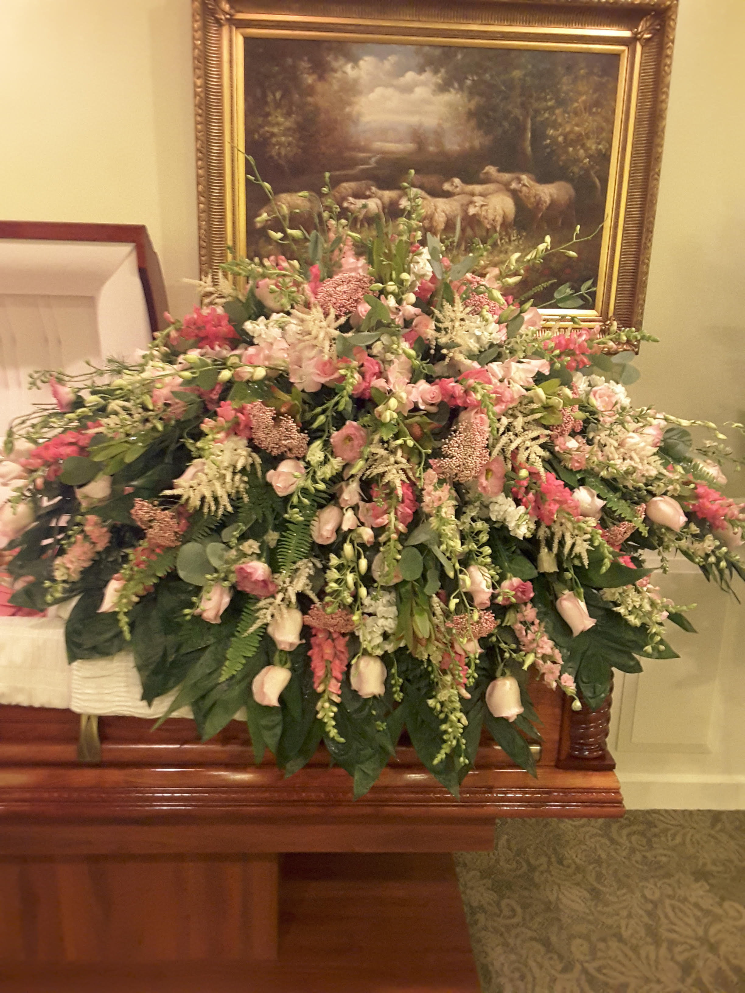 Large pink and white floral spray on a casket