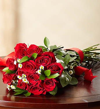 Bouquet of red roses with small white daisies and greenery
