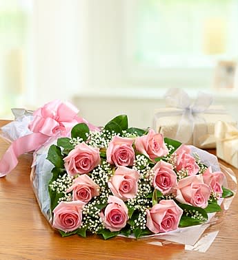 Bouquet of pink roses with baby's breath wrapped in paper
