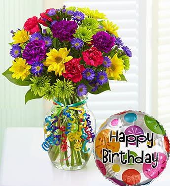 Colorful bouquet in a glass vase with a Happy Birthday balloon