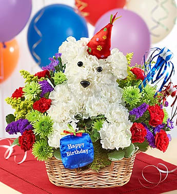 White teddy bear floral arrangement in a basket with birthday decorations