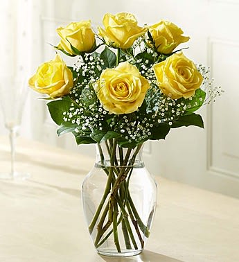 Yellow roses arranged in a clear glass vase