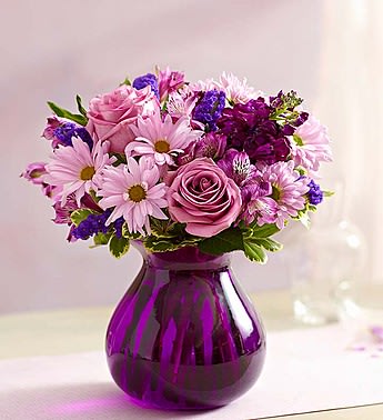 Pink and purple bouquet in a purple glass vase
