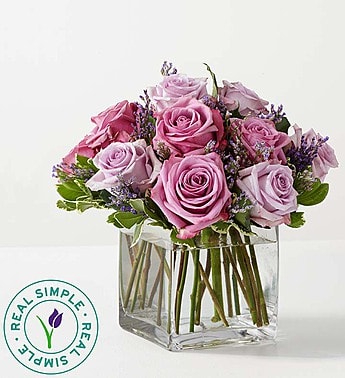Pink and lavender roses in a clear square vase