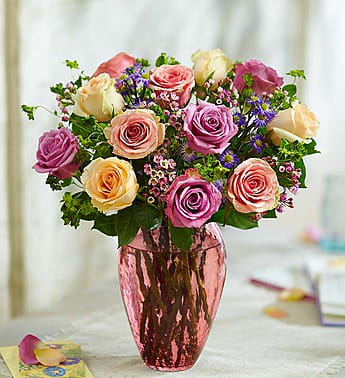 Bouquet of pink, cream, and purple roses in a metallic vase