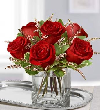 Red roses arranged in a clear glass vase