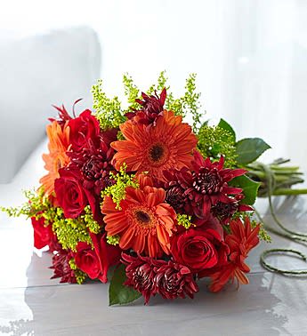 Bouquet of red and orange flowers with green accents