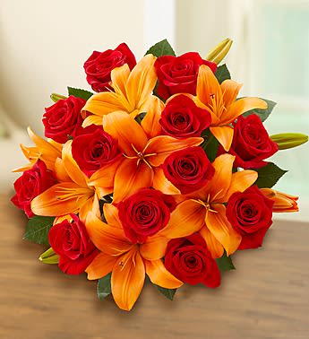 Bouquet of red roses and orange lilies on a table