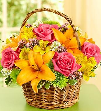 Basket of pink roses and orange lilies with yellow flowers