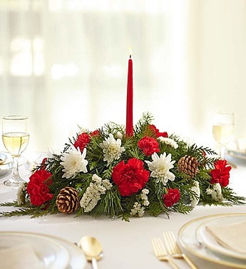 Holiday centerpiece with red and white flowers and a tall red candle
