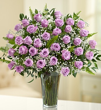 Lavender roses arranged in a clear glass vase