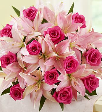 Pink roses and pale lilies arranged in a bouquet