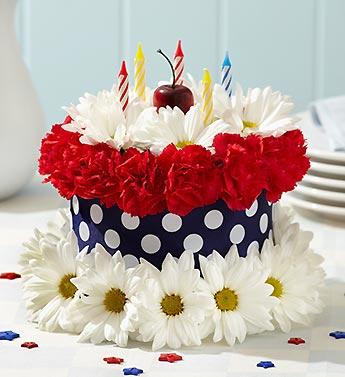 Cake decorated with red and white flowers and striped candles