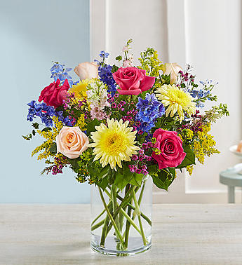 Mixed bouquet of roses and daisies in a clear glass vase