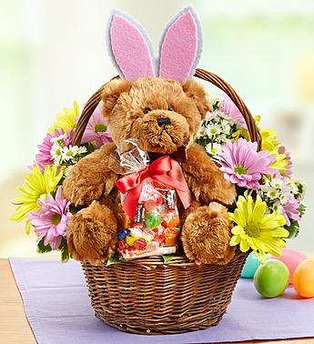 Teddy bear in a wicker basket with pastel flowers and bunny ears
