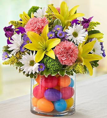 Colorful bouquet in a glass vase filled with bright eggs