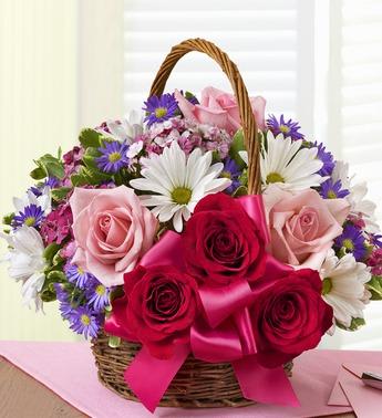 Basket of pink and red roses with white daisies and purple flowers