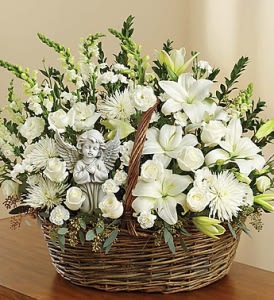 White floral basket arrangement with an angel figurine
