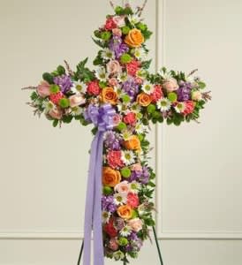 Cross-shaped floral standing spray with multicolored flowers and a lavender ribbon