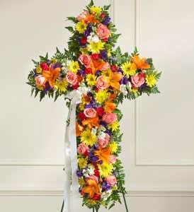 Cross-shaped floral arrangement with pink roses, lilies, and yellow daisies