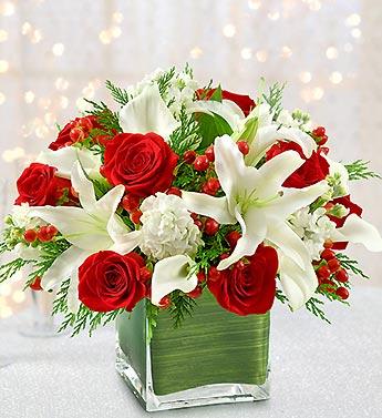 Red roses and white lilies arranged in a square glass vase