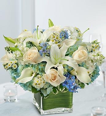 White lilies and cream roses in a square glass vase