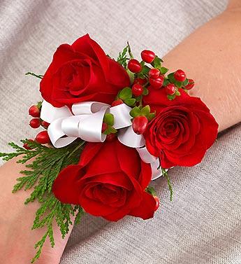 Red rose wrist corsage with white ribbon and berries