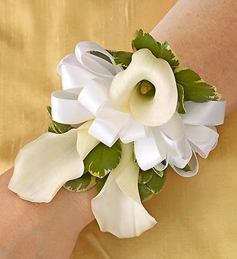 White calla lily wrist corsage with ribbon and green accents