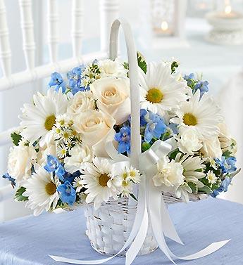White basket of daisies, roses, and blue flowers with a ribbon