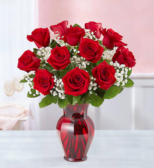Red roses and white baby's breath in a red glass vase