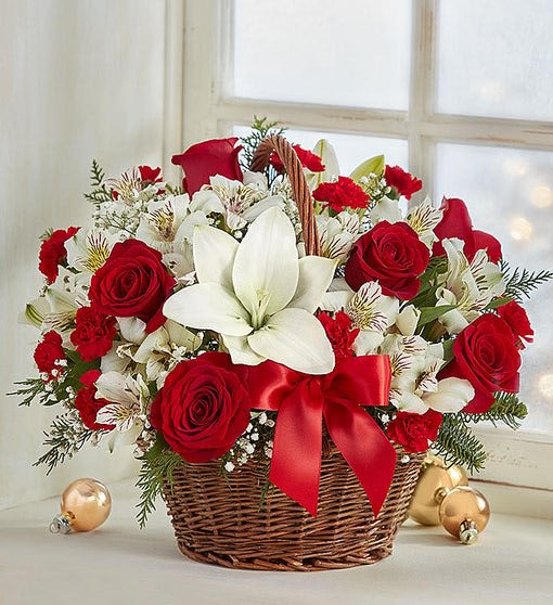 Basket arrangement of red roses and white lilies with a red ribbon