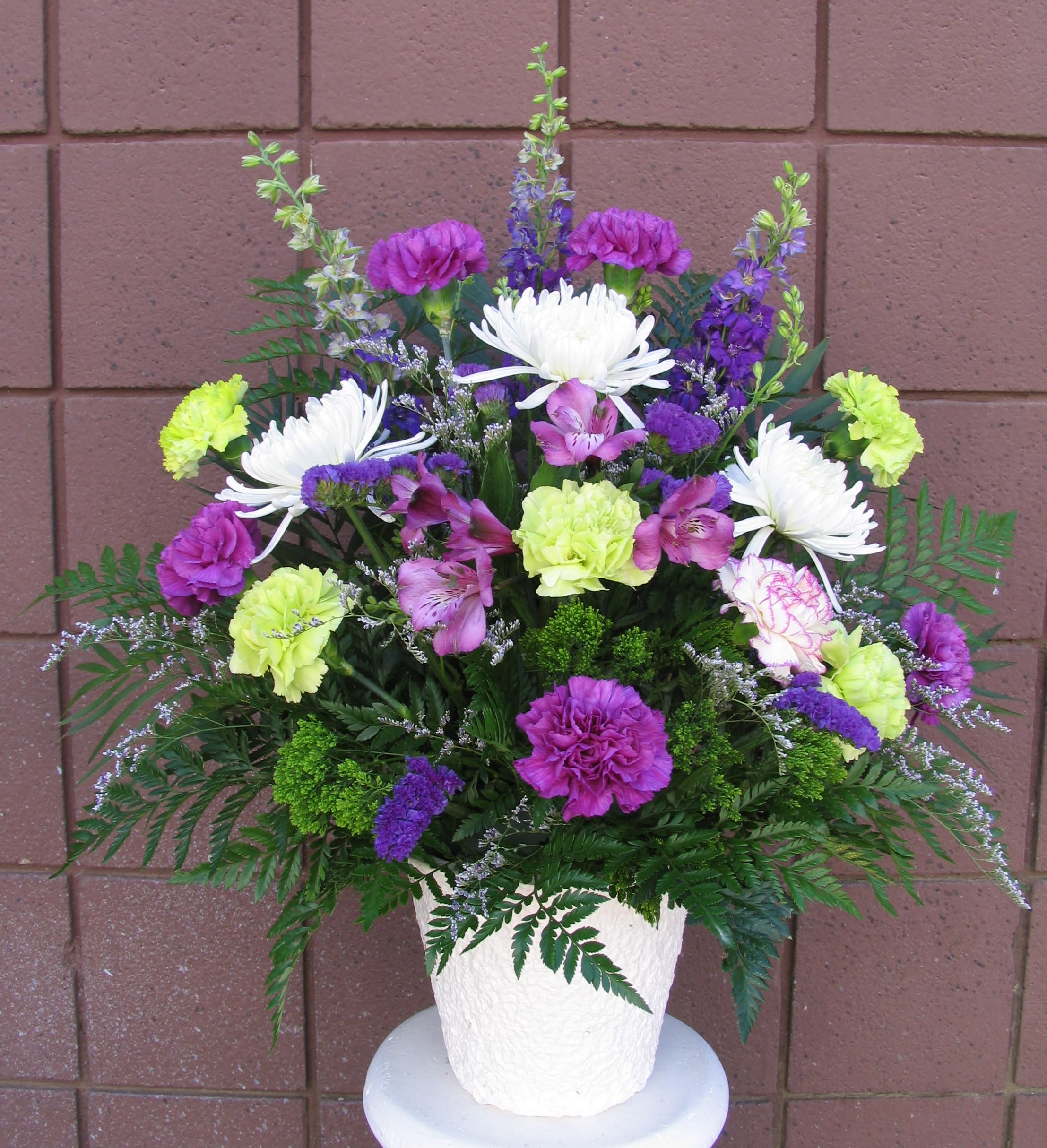 Colorful mixed flower arrangement in a white pot
