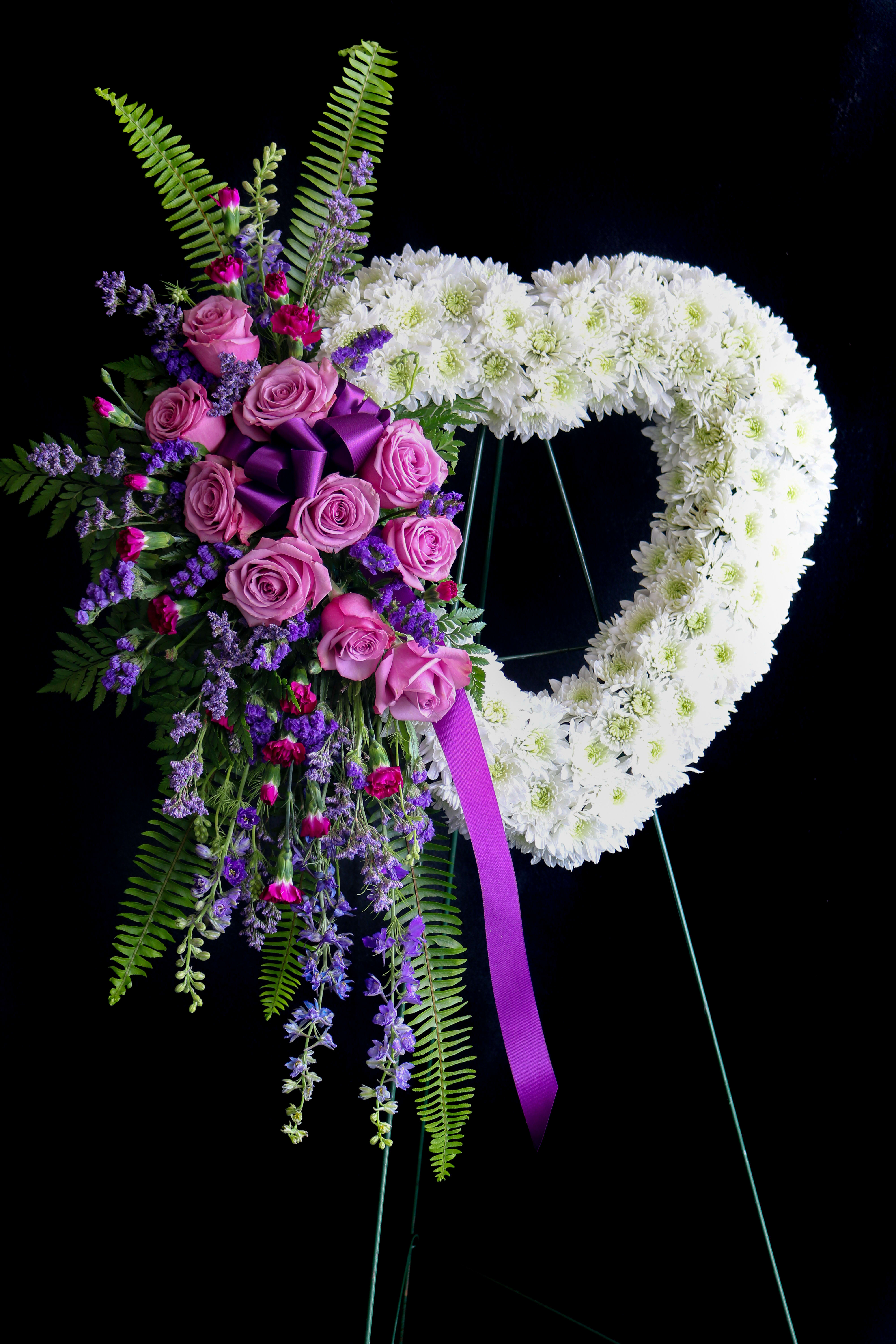 Heart-shaped floral wreath with pink roses and white chrysanthemums